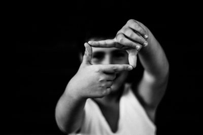 Midsection of woman using smart phone against black background