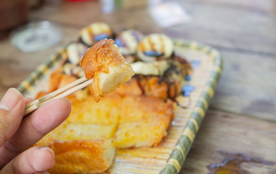 Close-up of hand holding bread on table