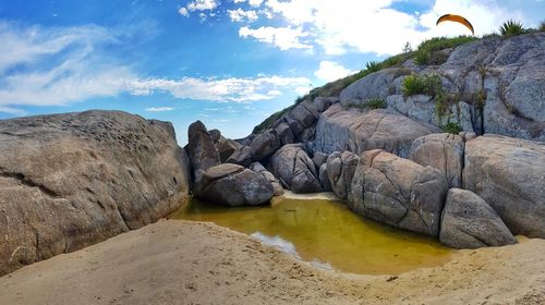 Rocks on beach against sky
