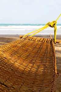 Close-up of rope on sand at beach against sky