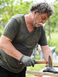 Midsection of man holding camera while standing outdoors