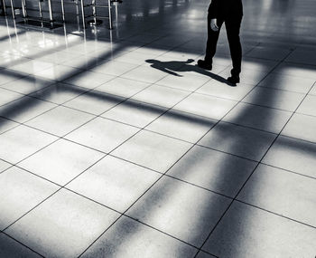 Low section of woman walking on tiled floor