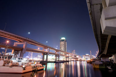 Illuminated city against clear sky at night