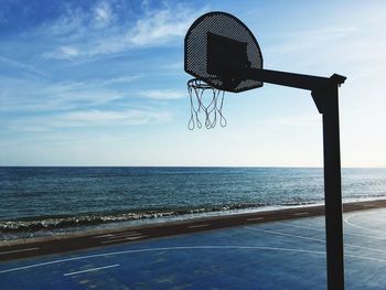 Basketball hoop on sea against sky