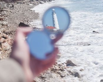 Person holding umbrella on beach