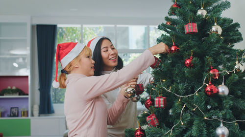 Woman standing by christmas tree at park