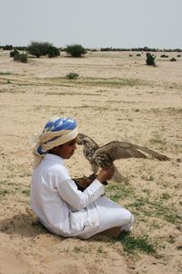 Rear view of man sitting on field