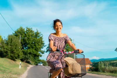 Smiling woman riding bicycle on road