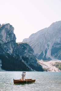 Man on boat in lake against clear sky