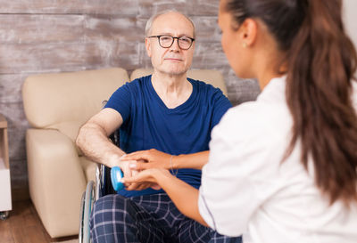 Midsection of woman sitting on sofa at home