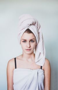 Portrait of young woman against white background