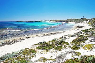 Scenic view of beach against clear blue sky