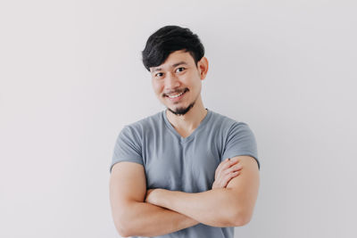 Portrait of smiling young man against white background