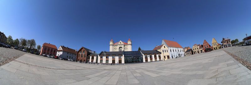 Buildings in city against clear blue sky