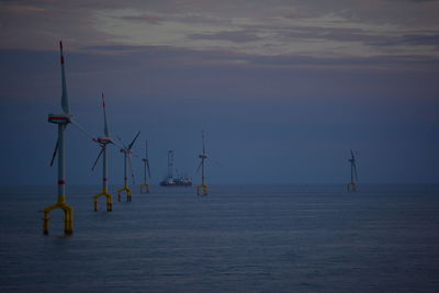 Sailboats in sea against sky during sunset