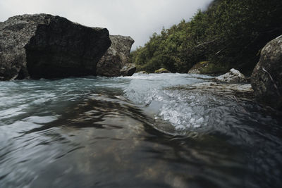 Rock formation in sea against sky