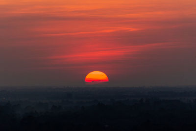 Silhouette landscape against orange sky