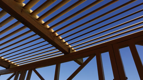 Low angle view of wood material structure against sky