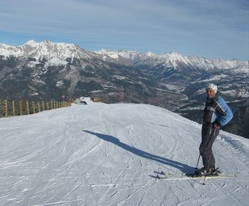 Full length of mature man skiing on snowcapped mountain against sky