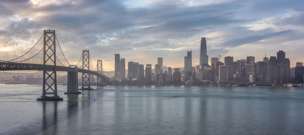 View of bay bridge over sea and buildings against sky san francisco 