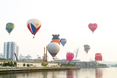 Hot air balloon flying over water against sky