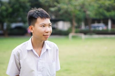 Young man looking away at park