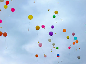Low angle view of balloons flying against sky