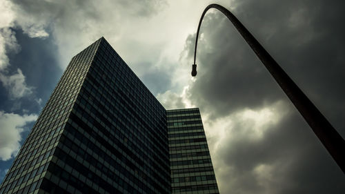 Low angle view of modern building against cloudy sky