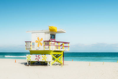 Lifeguard hut on beach against sky