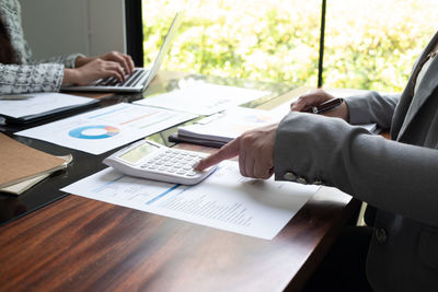 Midsection of businessman working on table