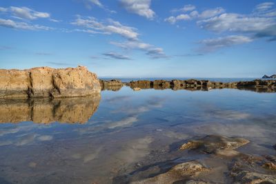 Rocks on beach against sky