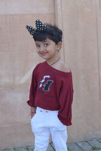 Portrait of boy standing against wall