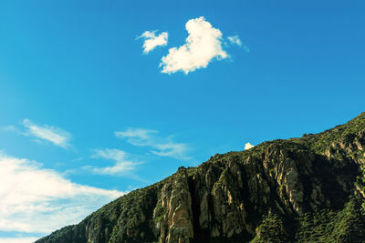 Low angle view of mountain against blue sky