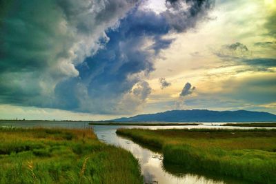 Scenic view of lake against cloudy sky