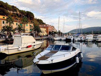 Boats moored at harbor against sky