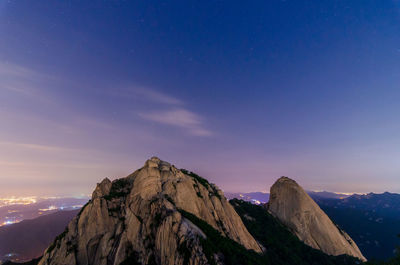 Scenic view of mountains against blue sky at night