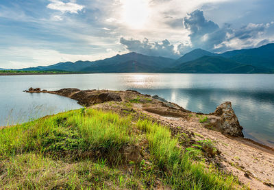 Scenic view of lake by mountains against sky