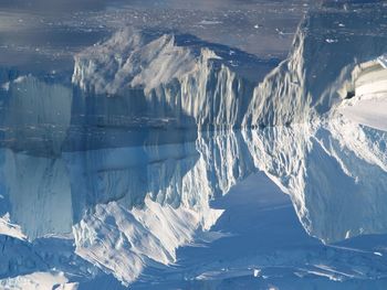 Upside down image of glaciers reflecting on sea