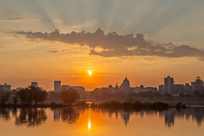 View of buildings at waterfront during sunset