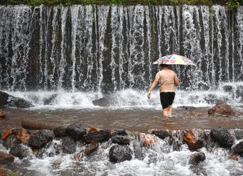 Rear view of woman standing in water