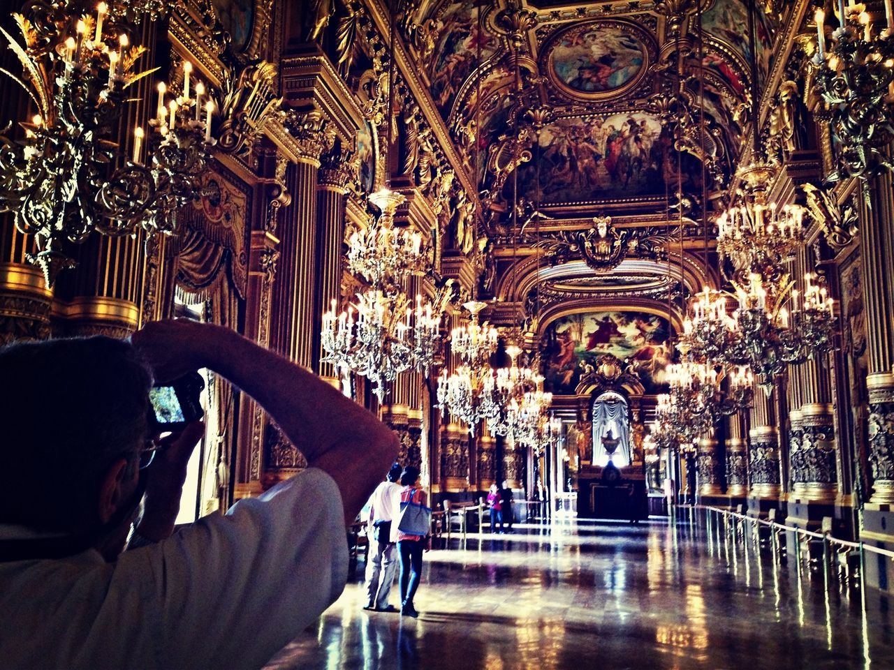 indoors, lifestyles, men, leisure activity, person, architecture, built structure, rear view, religion, illuminated, arch, place of worship, spirituality, incidental people, casual clothing, travel destinations, unrecognizable person