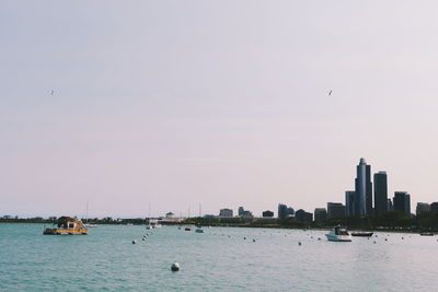 Boats in river with cityscape in background