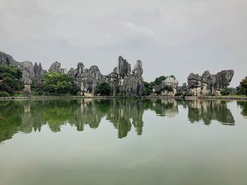 Reflection of rocks in lake against sky