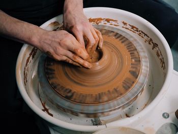 Hands of man working in pottery workshop