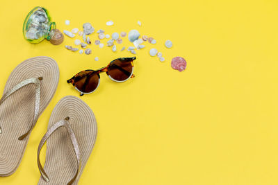High angle view of sunglasses on table against yellow background