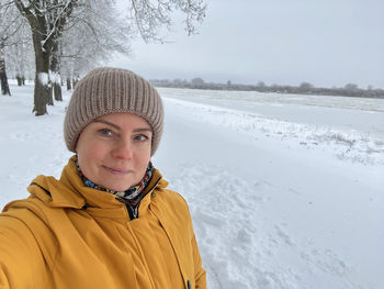 Portrait of woman standing on snow covered landscape