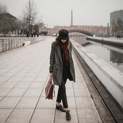 Woman standing on snow covered city in winter