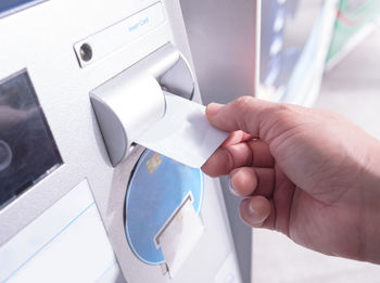 Close-up of person using atm machine