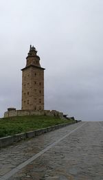 Tower by sea against sky