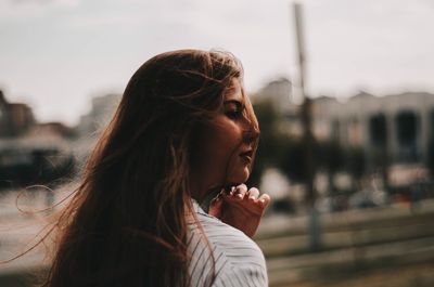 Portrait of young woman standing in city